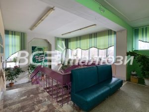 Зелёные полосатые вертикальные жалюзи с фигурным низом в холле