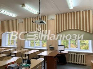 Бежевые полосатые вертикальные жалюзи дугой над окнами учебного класса