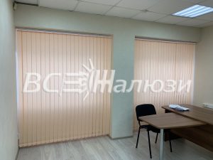 Персиковые вертикальные жалюзи на двух окнах кабинета со столом