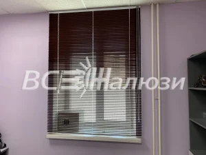 Тёмно-коричневые горизонтальные жалюзи на окне с сиреневыми стенами