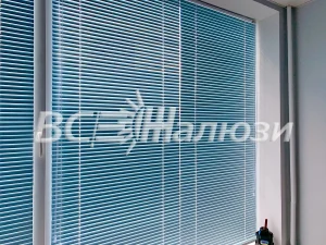 Синие горизонтальные жалюзи на окне, ламели почти закрыты