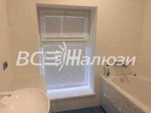 Белые горизонтальные жалюзи на окне ванной комнаты