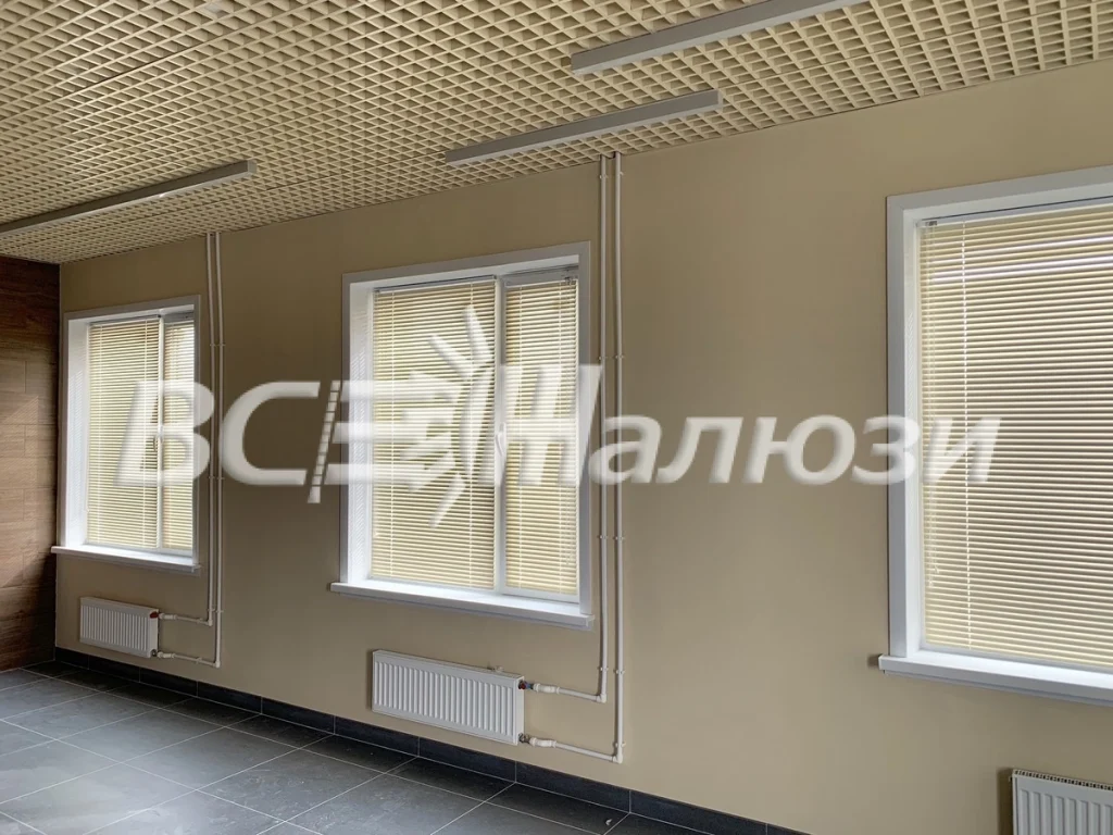 Бежевые горизонтальные жалюзи на трёх окнах вдоль стены