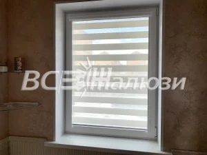 Белая штора зебра на окне, стены цвета какао