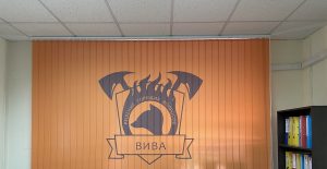 Вертикальные фотожалюзи с фирменной эмблемой «Вива» в кабинете с книжными полками