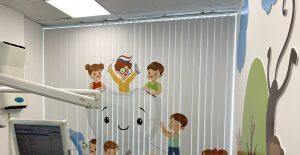 Вертикальные фотожалюзи с рисунком играющих детей в светлом кабинете