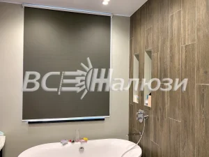 Тёмно-оливковая рулонная штора на окне ванной комнаты