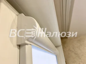 Крупный план короба рулонной шторы в углу окна