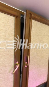 Бежевые рулонные шторы на деревянных створках, одна приоткрыта