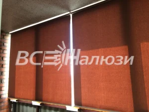 Терракотовые рулонные шторы на двух соседних окнах, вид вблизи