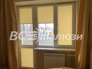 Бледно-жёлтые рулонные шторы на балконном блоке, центр приподнят