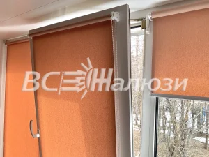 Оранжевые рулонные шторы на остеклении балкона, вид вблизи