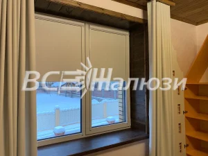 Светло-серые рулонные шторы на окне загородного дома зимой