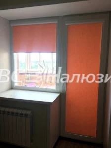 Оранжевые рулонные шторы на окне и балконной двери