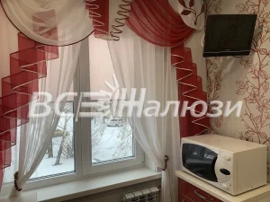 Рулонная штора за тюлем на кухонном окне с красно-белым ламбрекеном
