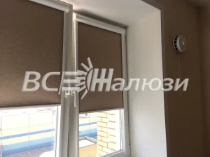 Кофейные рулонные шторы на двух створках окна светлой комнаты