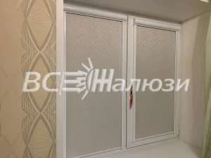 Белые рулонные шторы с мелким узором на двух створках окна
