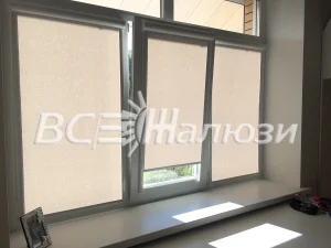 Светло-бежевые рулонные шторы на трёх секциях окна, широкий подоконник