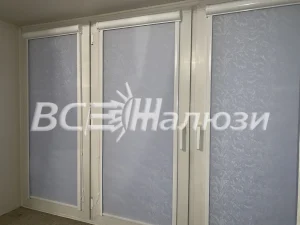 Светлые фактурные рулонные шторы на трёх створках в пустой комнате