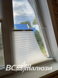 Плиссе на наклонной створке мансардного окна, вид вблизи