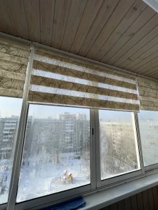 Балкон: полотно зебры собрано вверху, за стеклом снежный двор