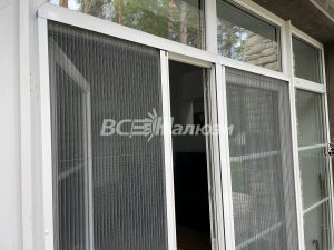 Раздвижные москитные сетки на белых дверях террасы, вид снаружи