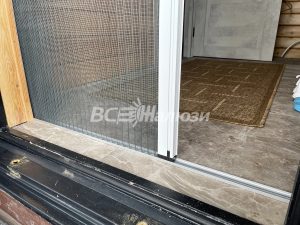 Край сетчатого полотна и белая планка у дверного порога