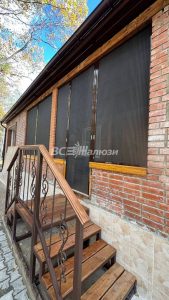 Сетки плиссе на окнах веранды кирпичного дома