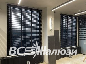 Просторный офис с чёрными жалюзи на двух больших окнах
