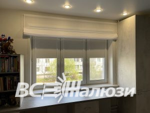 Белая римская штора валиком над широким окном комнаты
