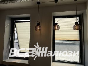 Два окна с кремовыми плиссе, левая створка открыта