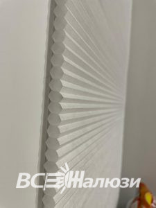 Крупный план белой плиссированной ткани, сложенной веером